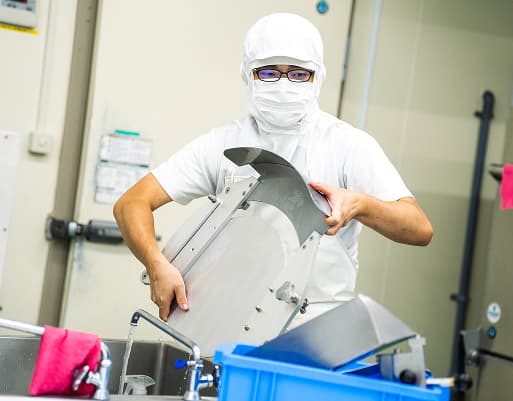 工場で作業するT.Kさん