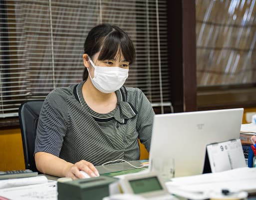事務所で仕事をするY.Kさん