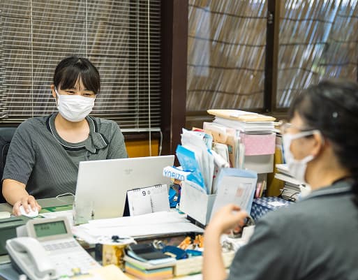事務所で仕事をするY.Kさん